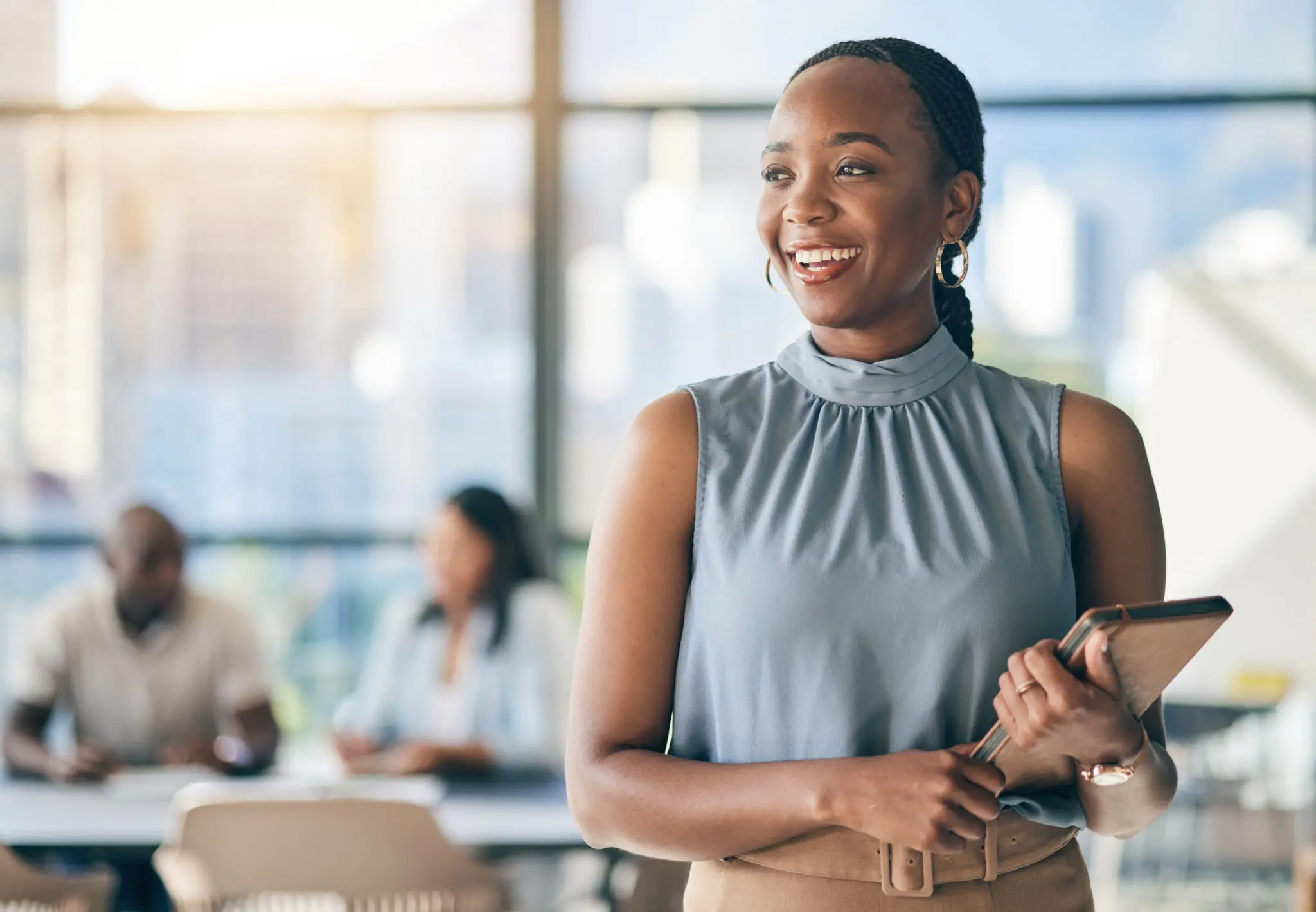 Confident woman smiling in a bright office setting.